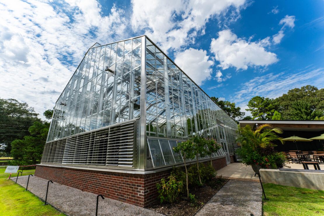 Conservatory glasshouse with sidewall vents and roof vents for cooling and ventilation