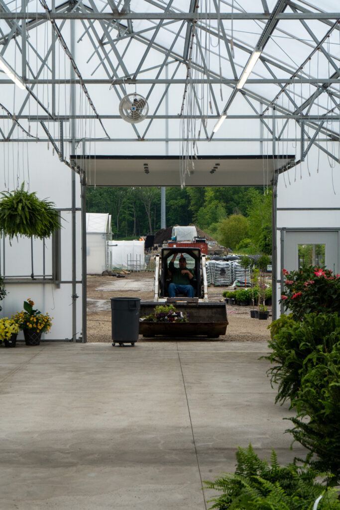 An overhead door at the back of this Vail a-frame greenhouse allows for easy access to load and unload plants and equipment.