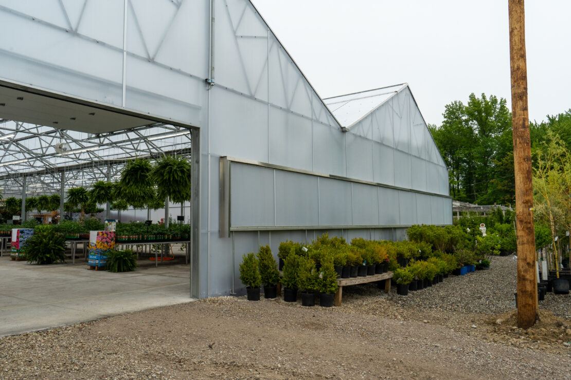 Rear entrance to Vail a-frame greenhouse showing overhead door for loading/unloading plants